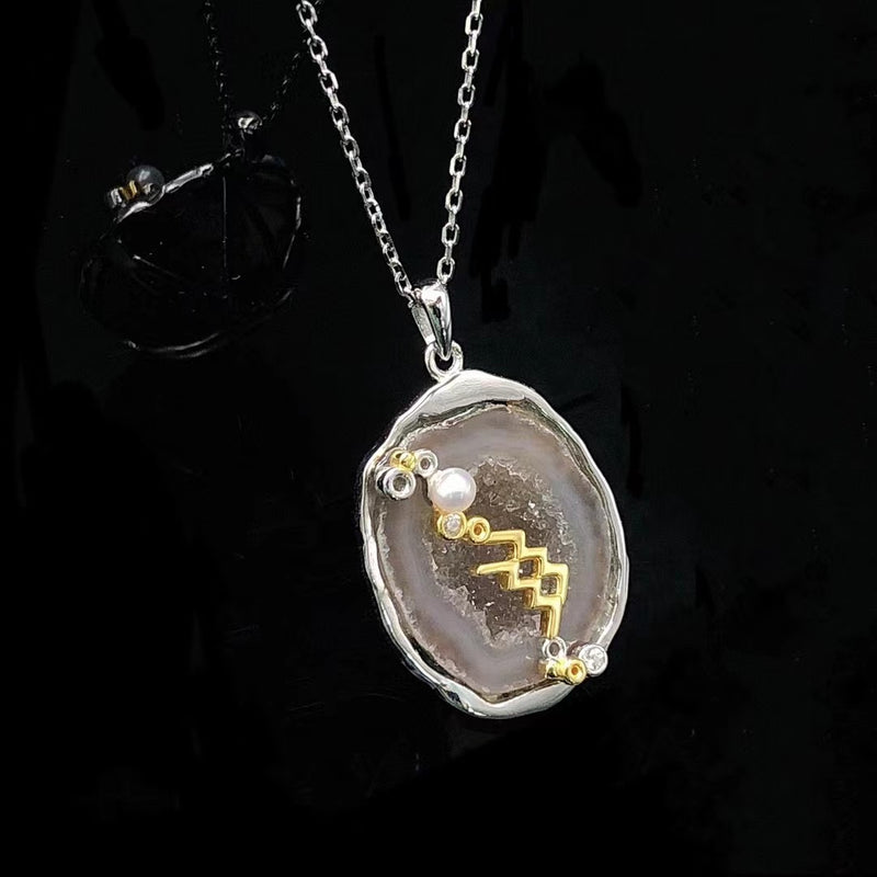 Aquarius crystal geode zodiac pendant with Aquarius symbol, angled view