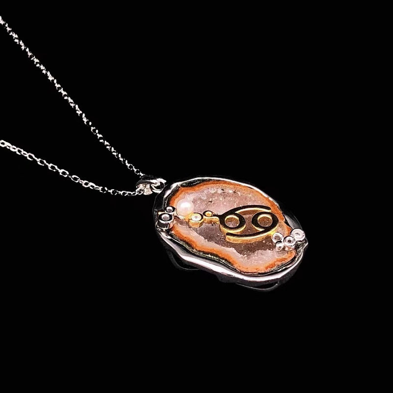 Cancer crystal geode zodiac pendant with Cancer symbol, angled view