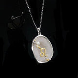 Leo crystal geode zodiac pendant with Leo symbol, angled view